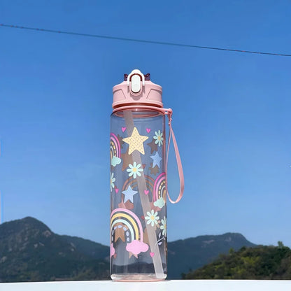 DinoSip Kids Water Bottle featuring a colorful rainbow and star design against a scenic outdoor background.