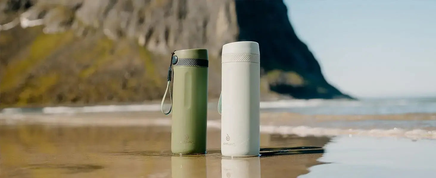 PureSip Thermal Bottle in green and white on a beach, showcasing their sleek and portable design.