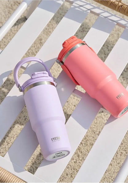 DuoSip Tumbler - insulated tumbler with dual-drink lid in pink and purple on a beach chair.